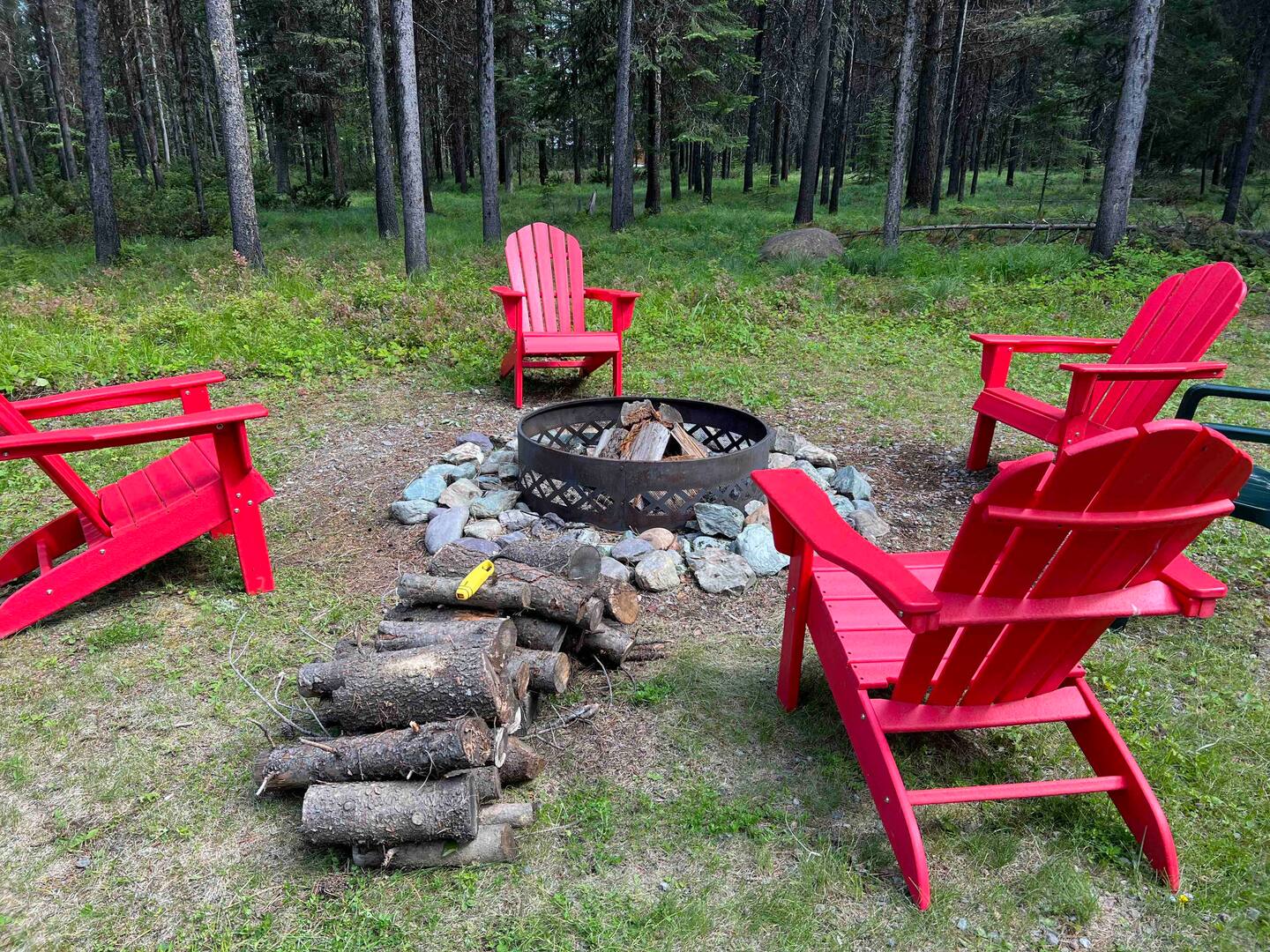 A place for campfire with four red chairs