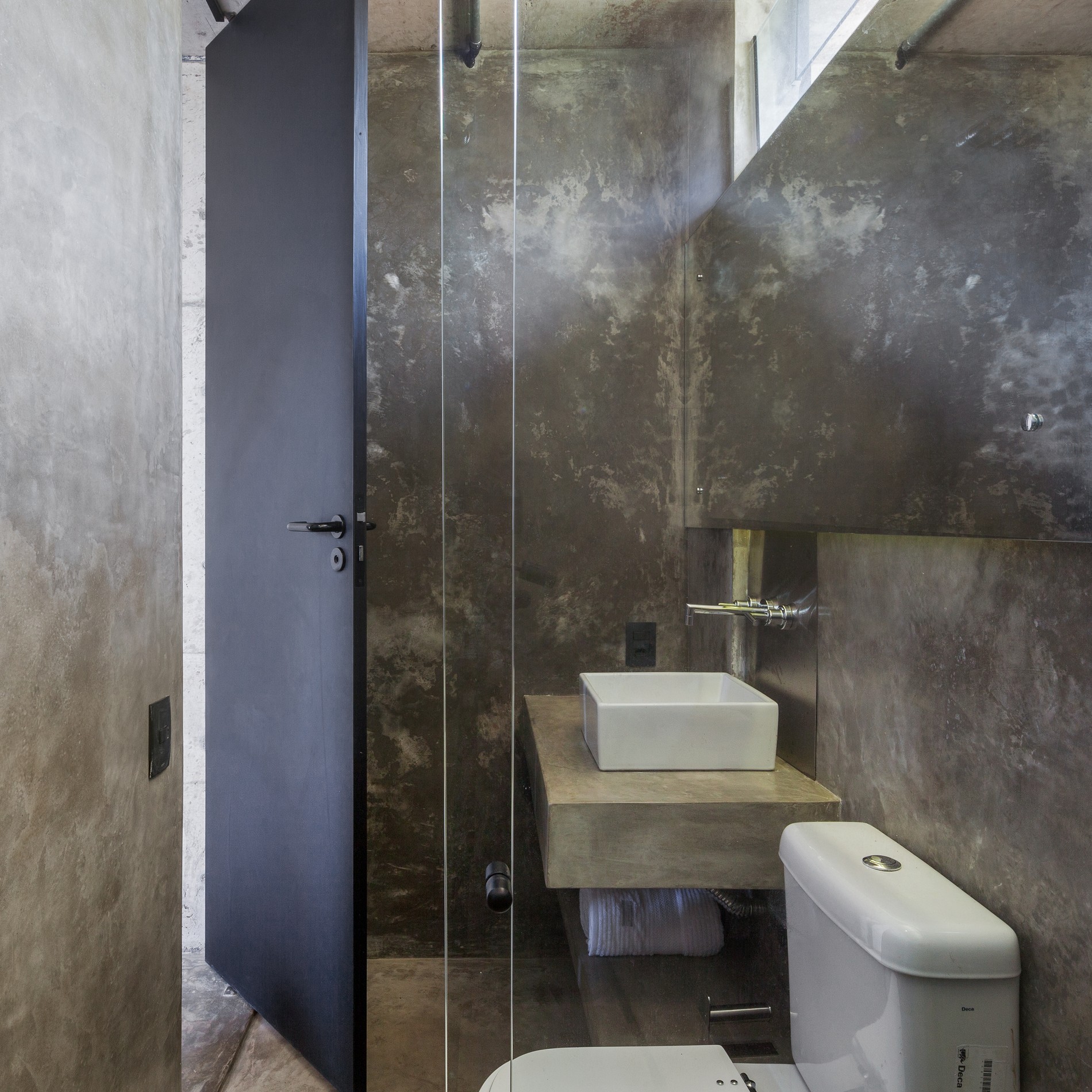 Gray bathroom without tiles and with white toilete and sink