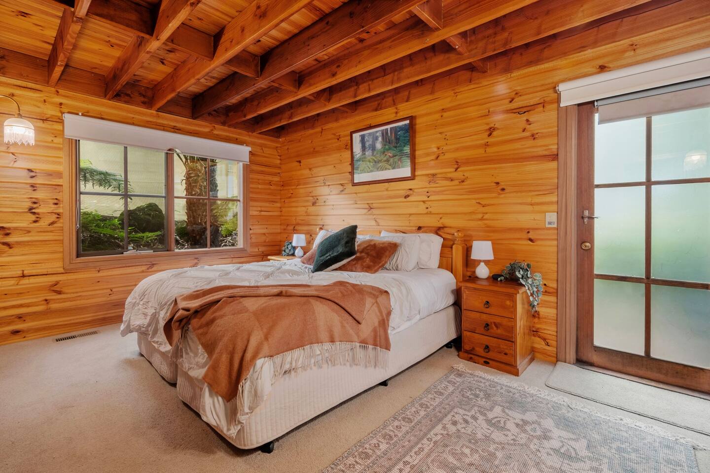 Comfy master bedroom with a queen sized bed and wooden nightstand