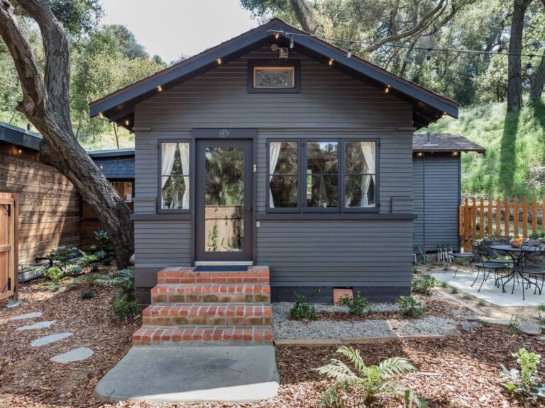 Black cabin, in nature, with glass door