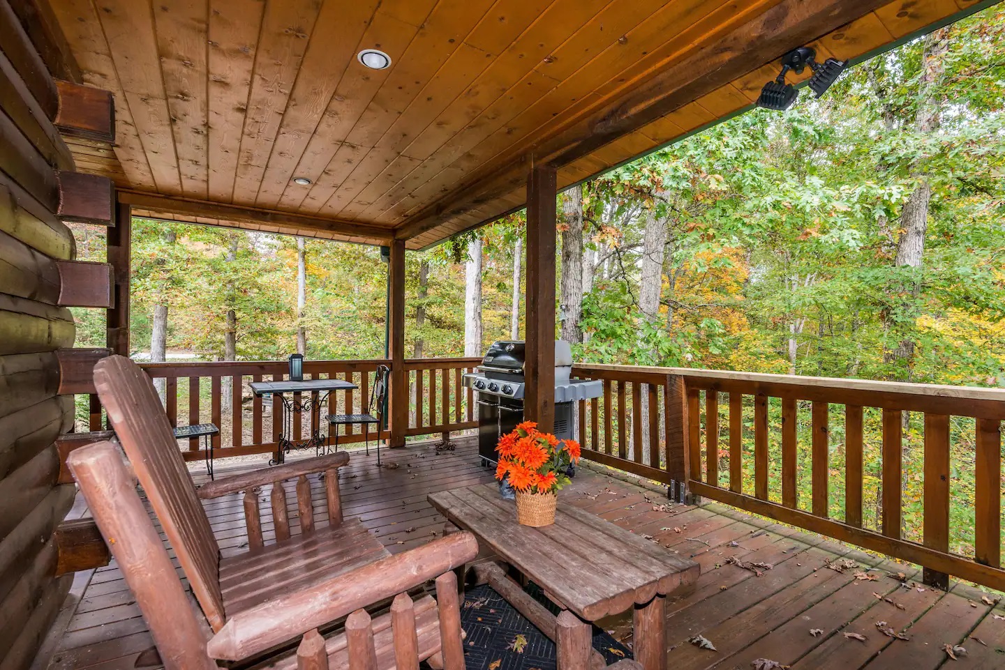 Fairytale Log Cabin barbecue on a porch with chair made of wood