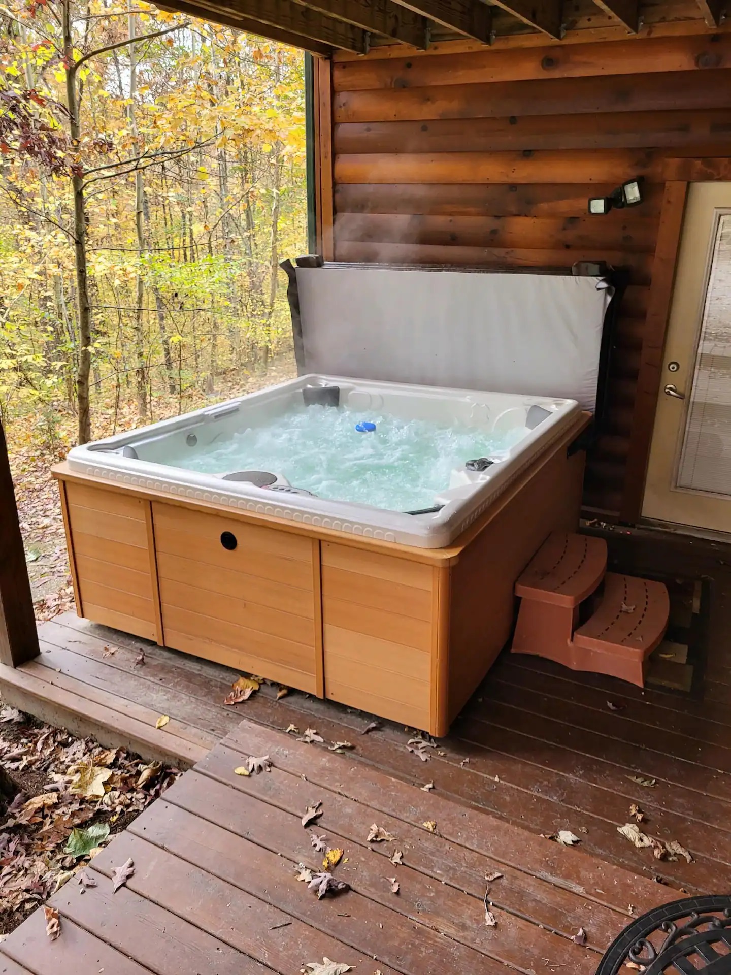 Fairytale Log Cabin jacuzzi on the porch outside the home