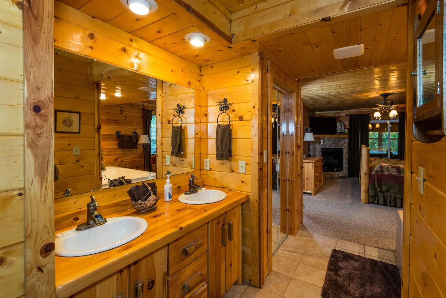 Fairytale Log Cabin master bathroom with huge mirror and two sinks