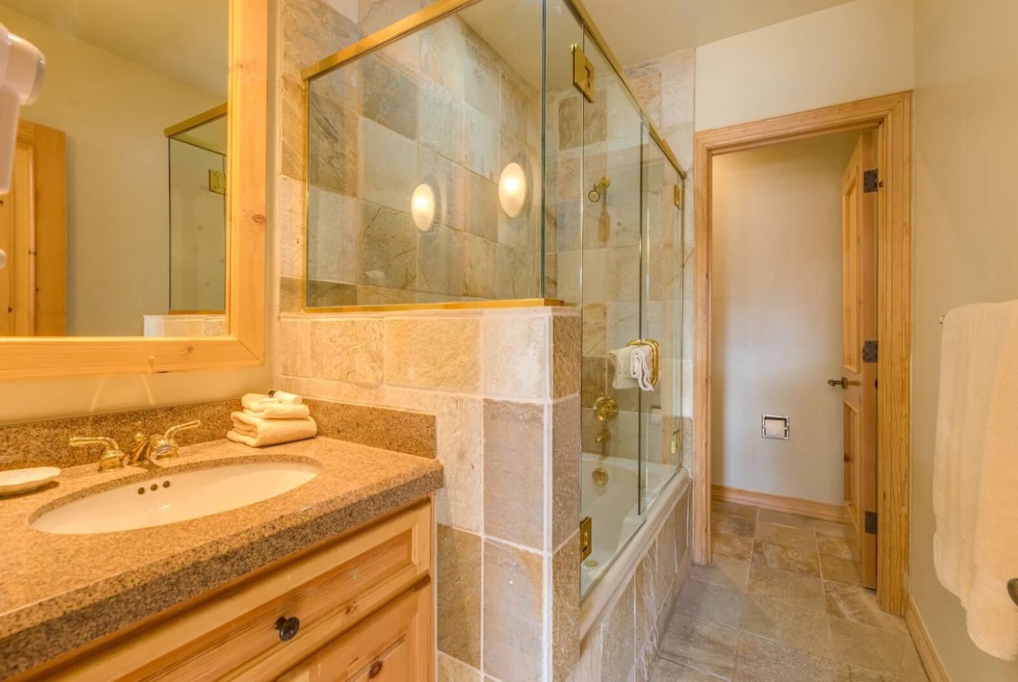 Glass shower in the bathroom with a golden frame