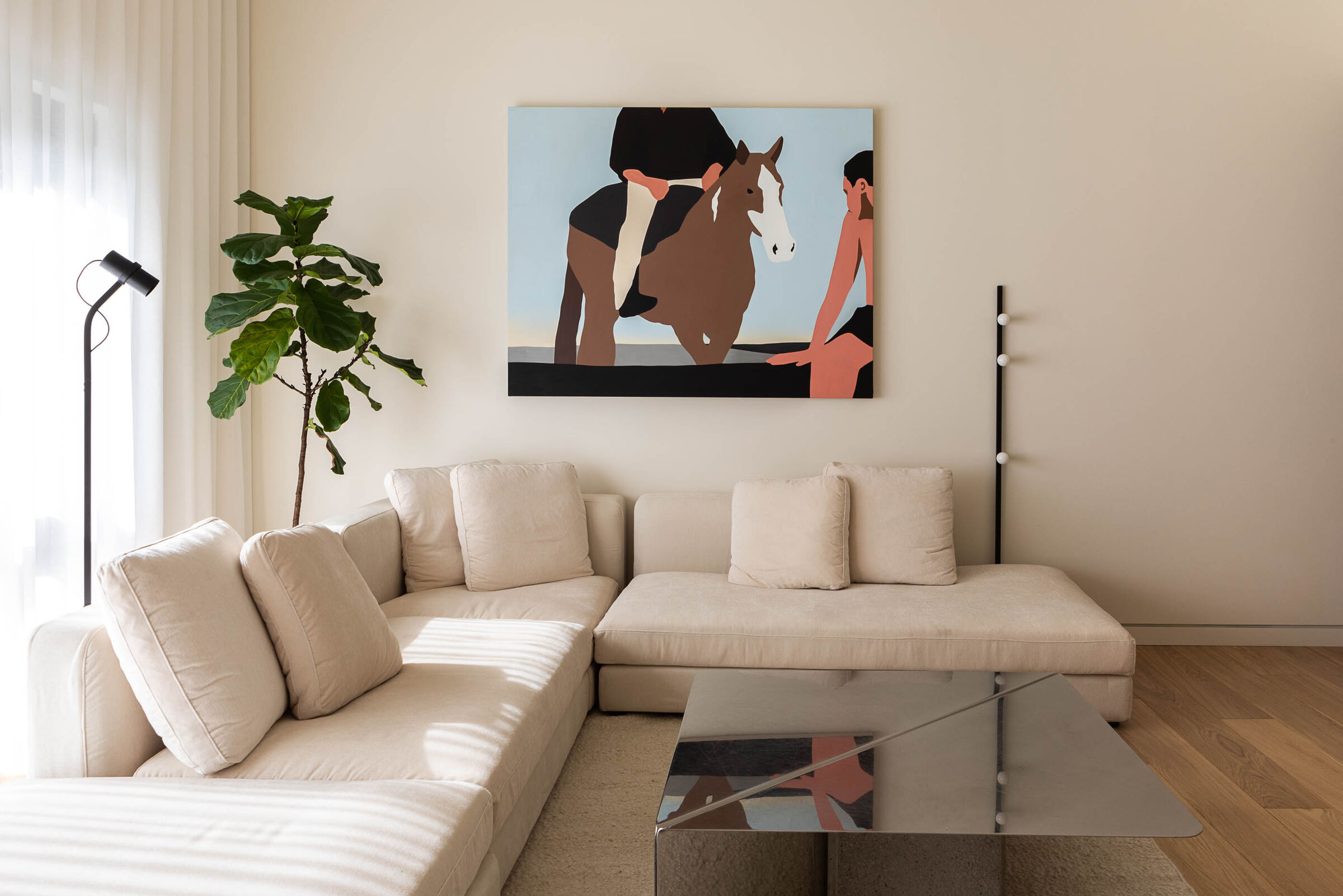 Living room with white couch, decorations and beautiful picture of a horse