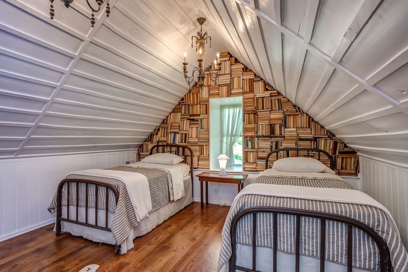 bedroom of a rustic cabin, wall made of books, two beds