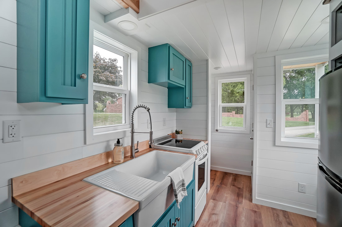 small kitchen, teal cabinets, wooden countertop and big windows