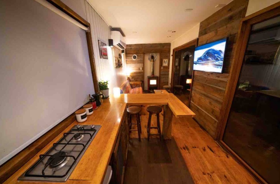 kitchen and living room of a container, wooden interior, glass door