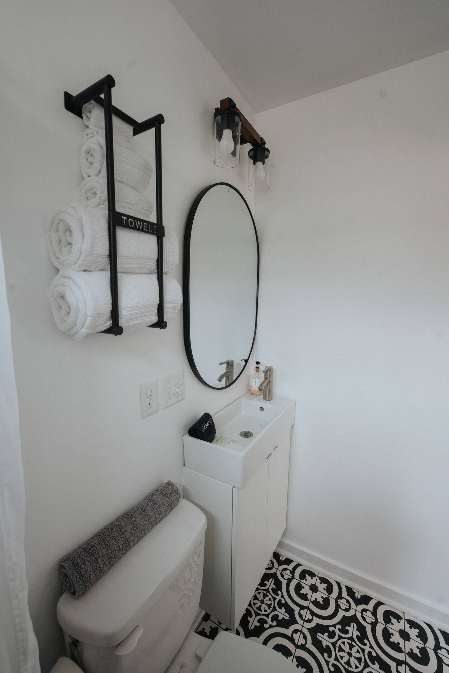 Black details in white toillette with a retro tiles and small sink