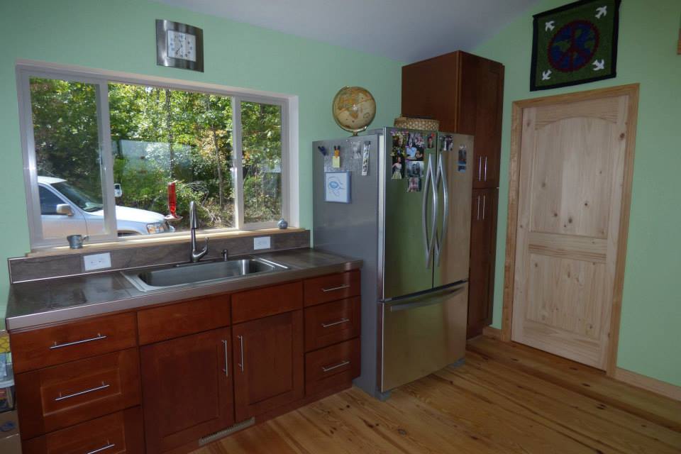 Small but useful kitchen,, with a large fridge and a window above the sink