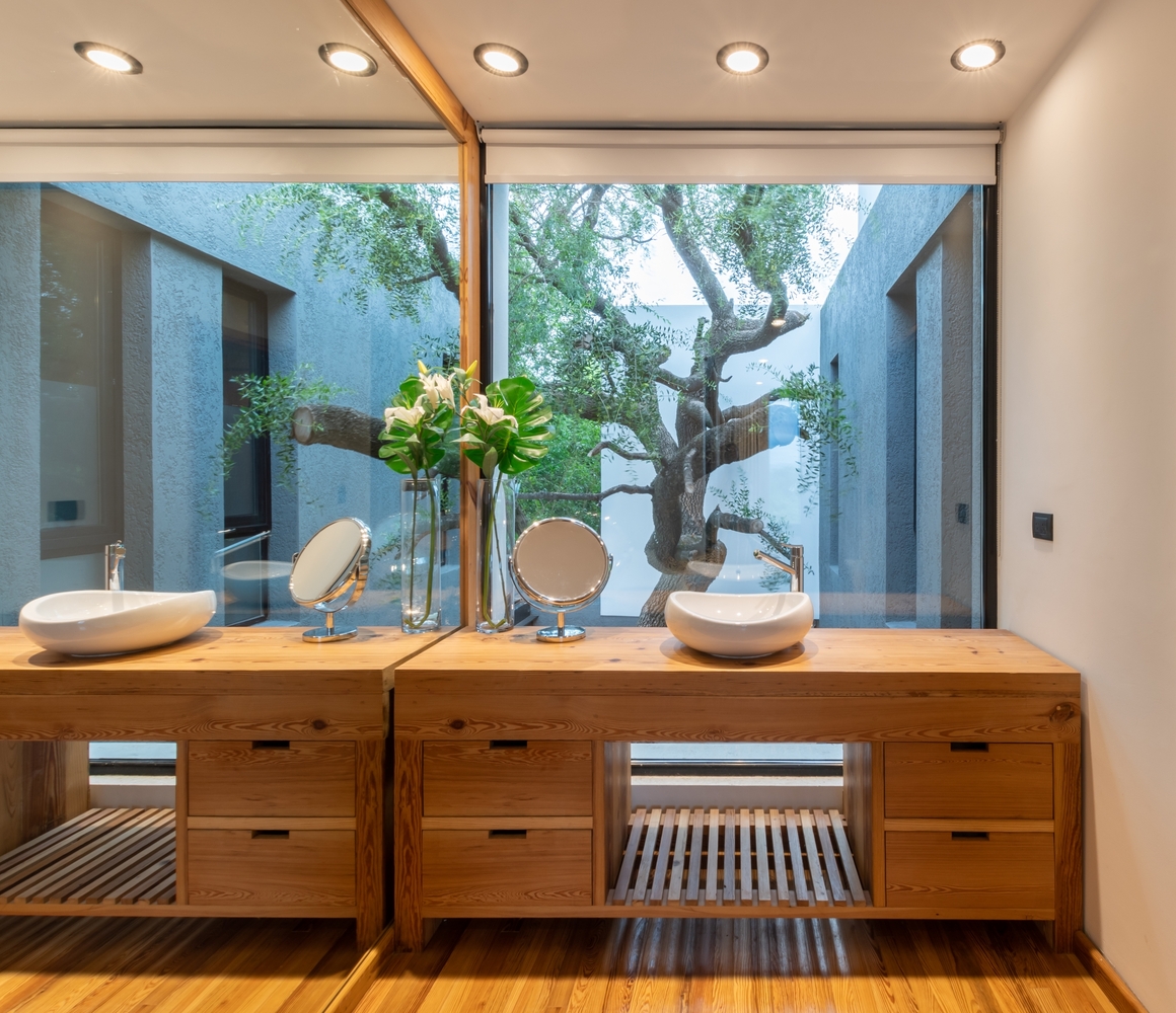 bathroom with a brown cabinet and a floor to ceiling mirror