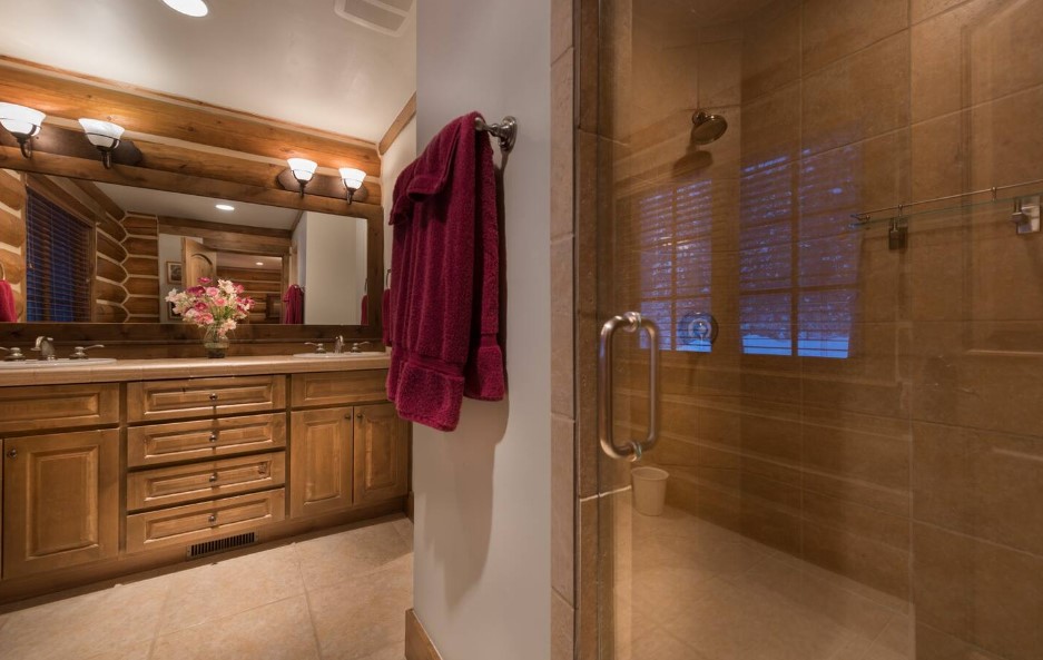 bathroom with a glass shower and a brown cabinet