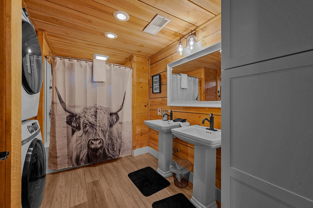 bathroom with a cow print on a shower curtain and a washing and drying machine