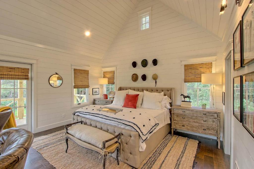 bedroom with a bedside table and windows all around