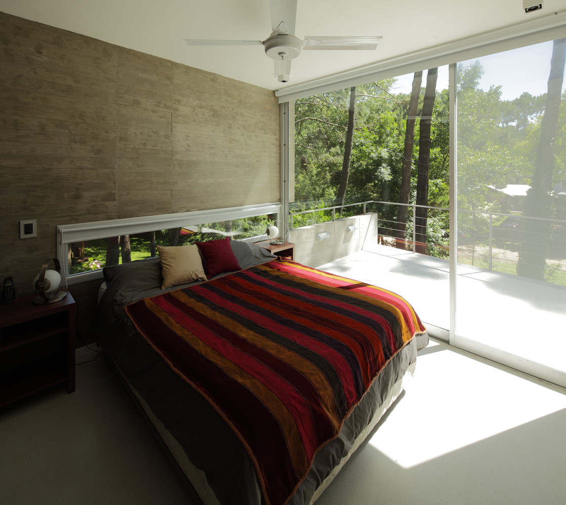 bedroom with a floor to ceiling window and a balcony