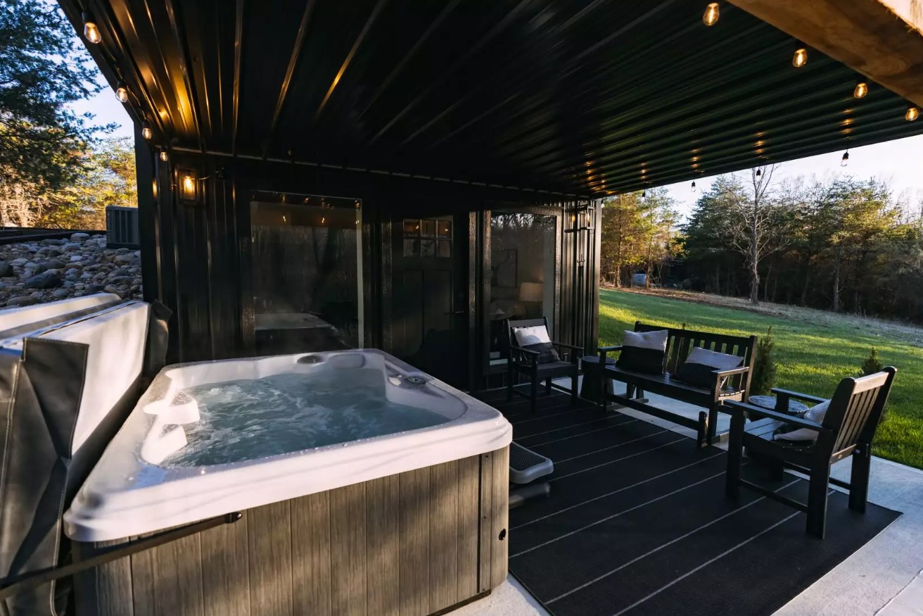 hot tub and black chairs outside of the house