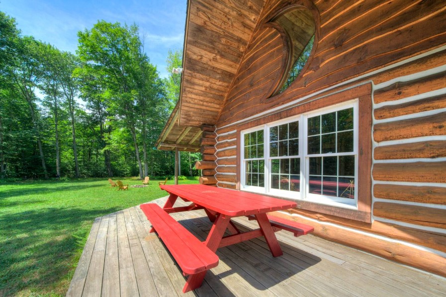 red dining table and two benches outside of the house