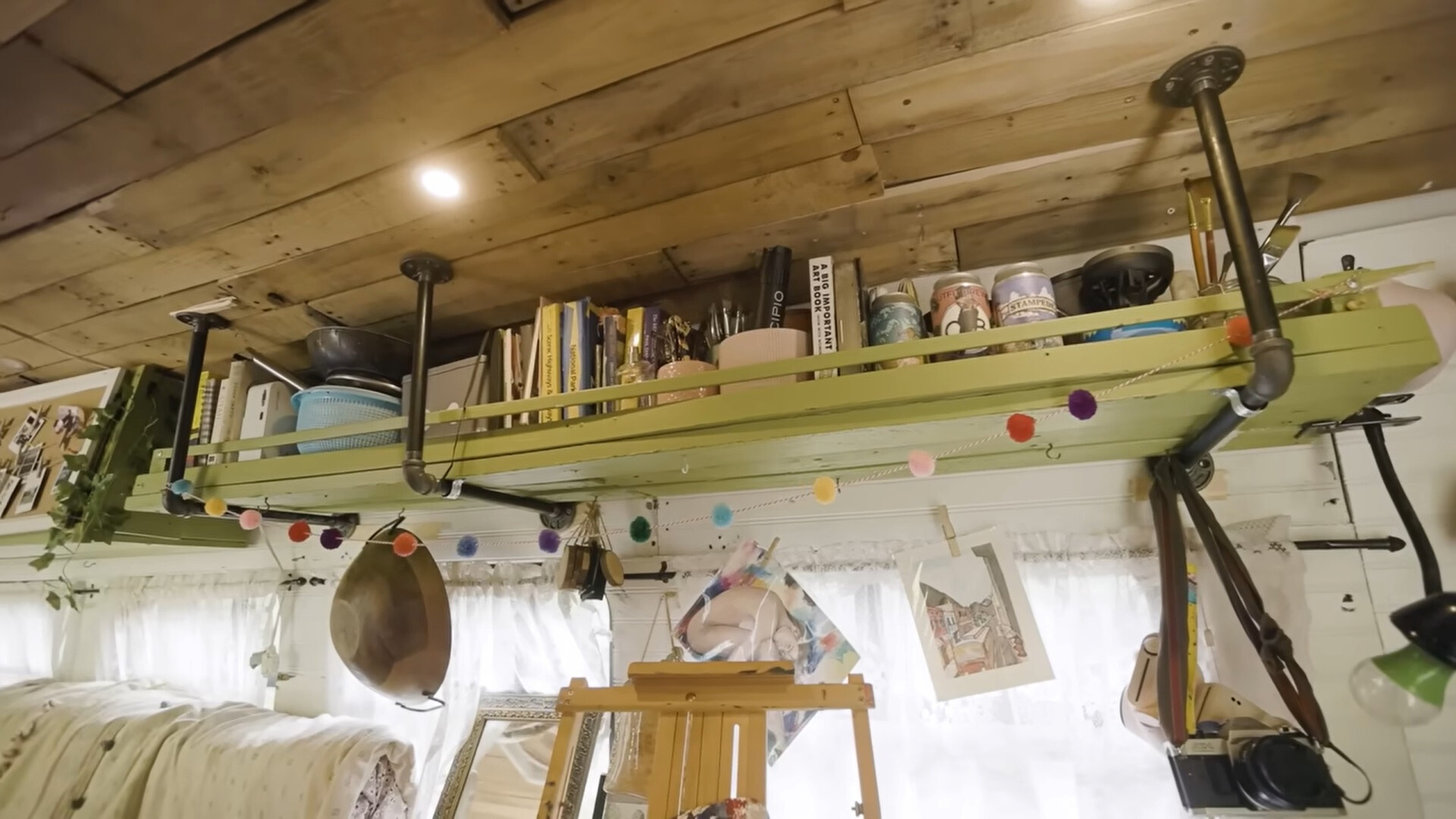 shelves above the desk inside a tiny house, full of art supplies
