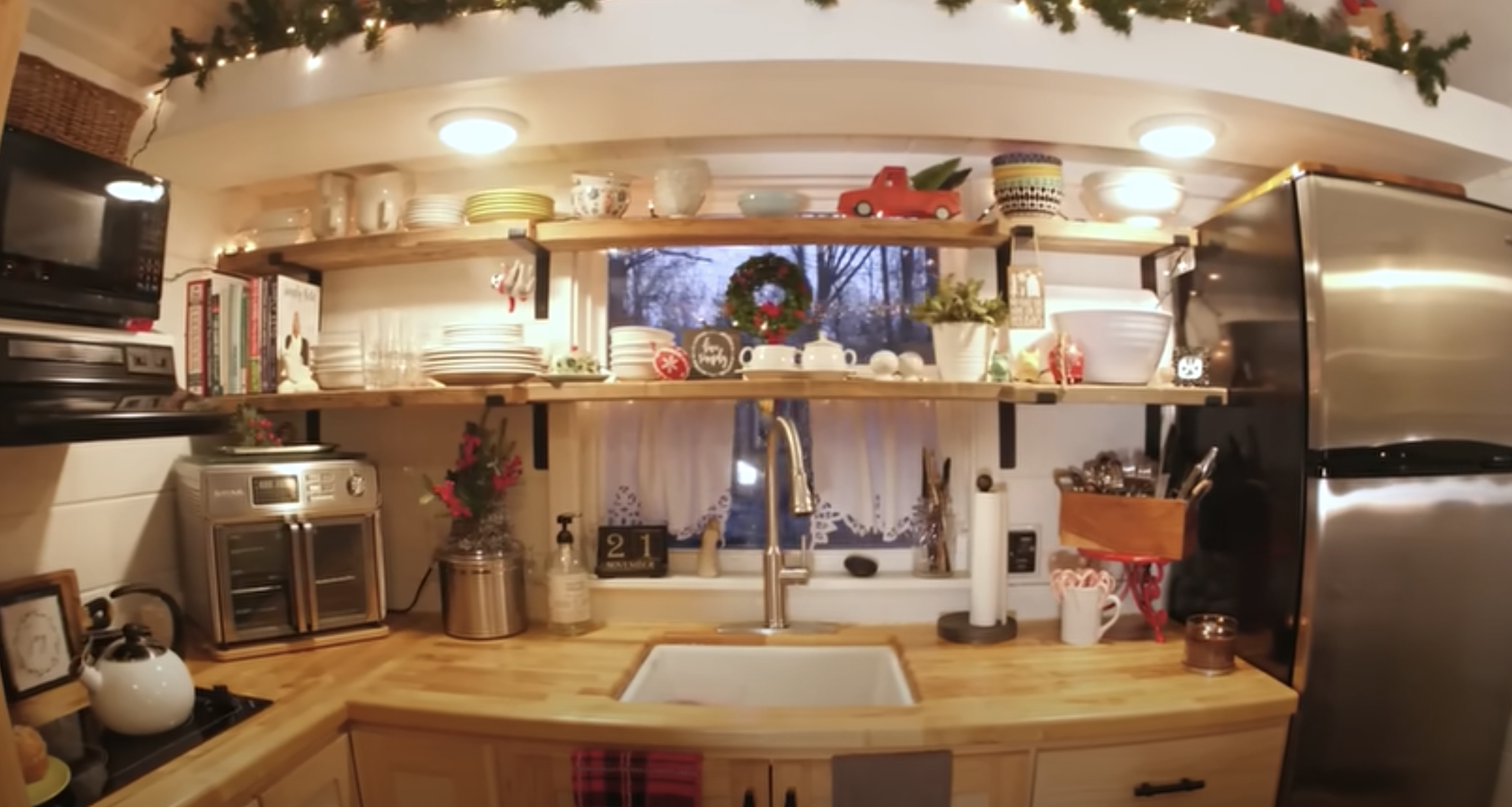 tiny house tiny kitchen with shelves, sink and kitchen appliances