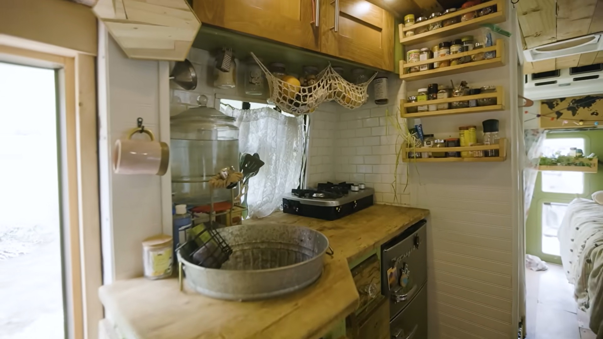 tiny kitchen with a brown countertop and a lot of shelves with spices