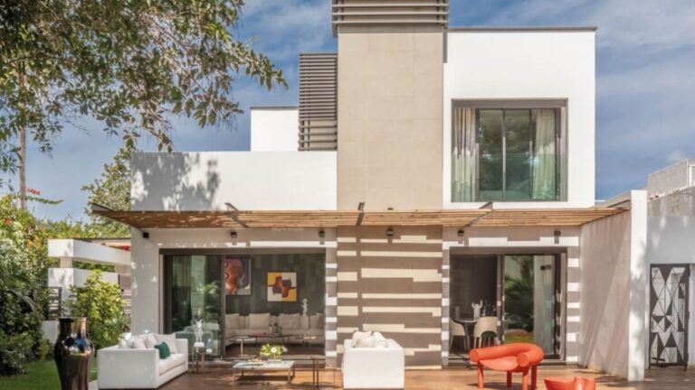exterior of a modern house with a pool and a white sitting area outside
