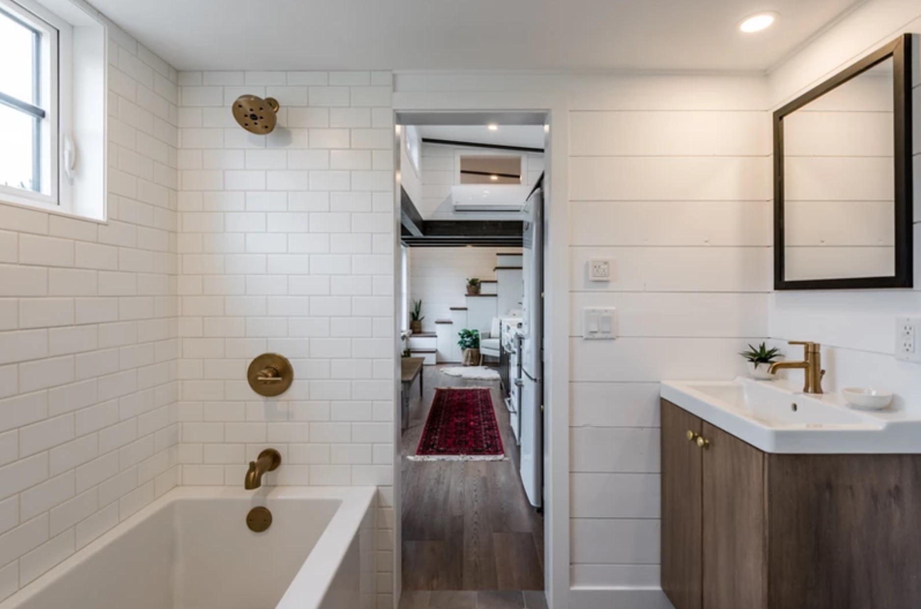 White bathroom with wooden and brass details