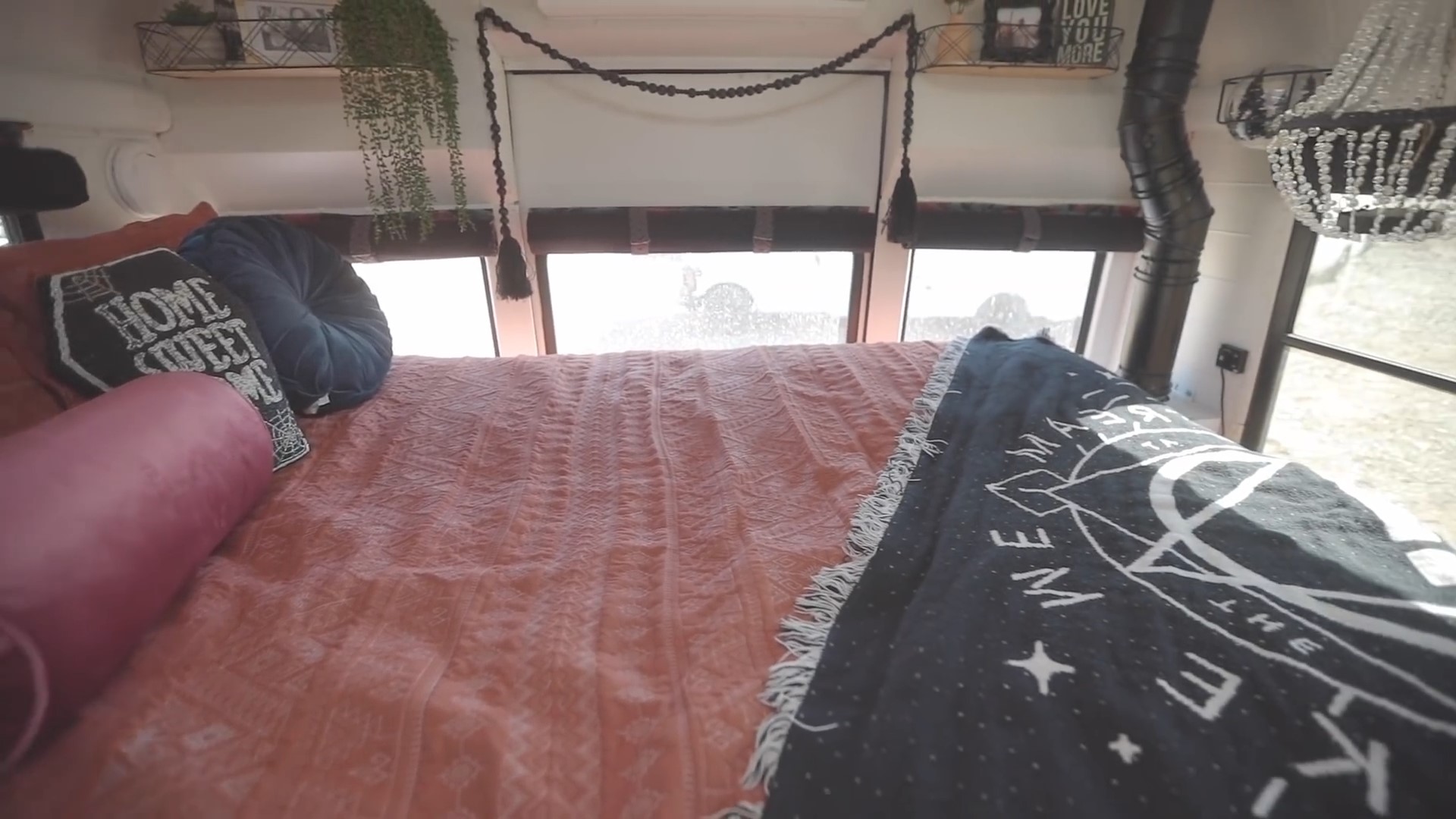 Bed room located on a house bus with a small chandelier