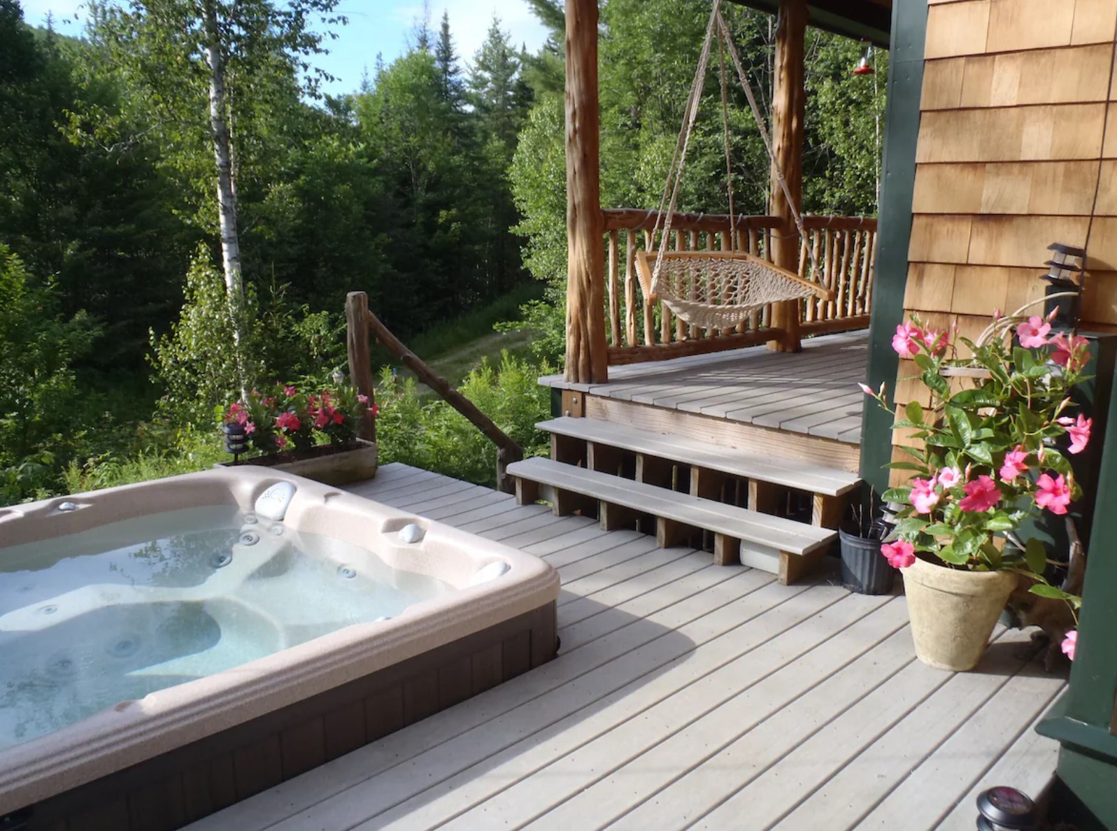 Wooden cabin with a hot tub and a swing on the deck