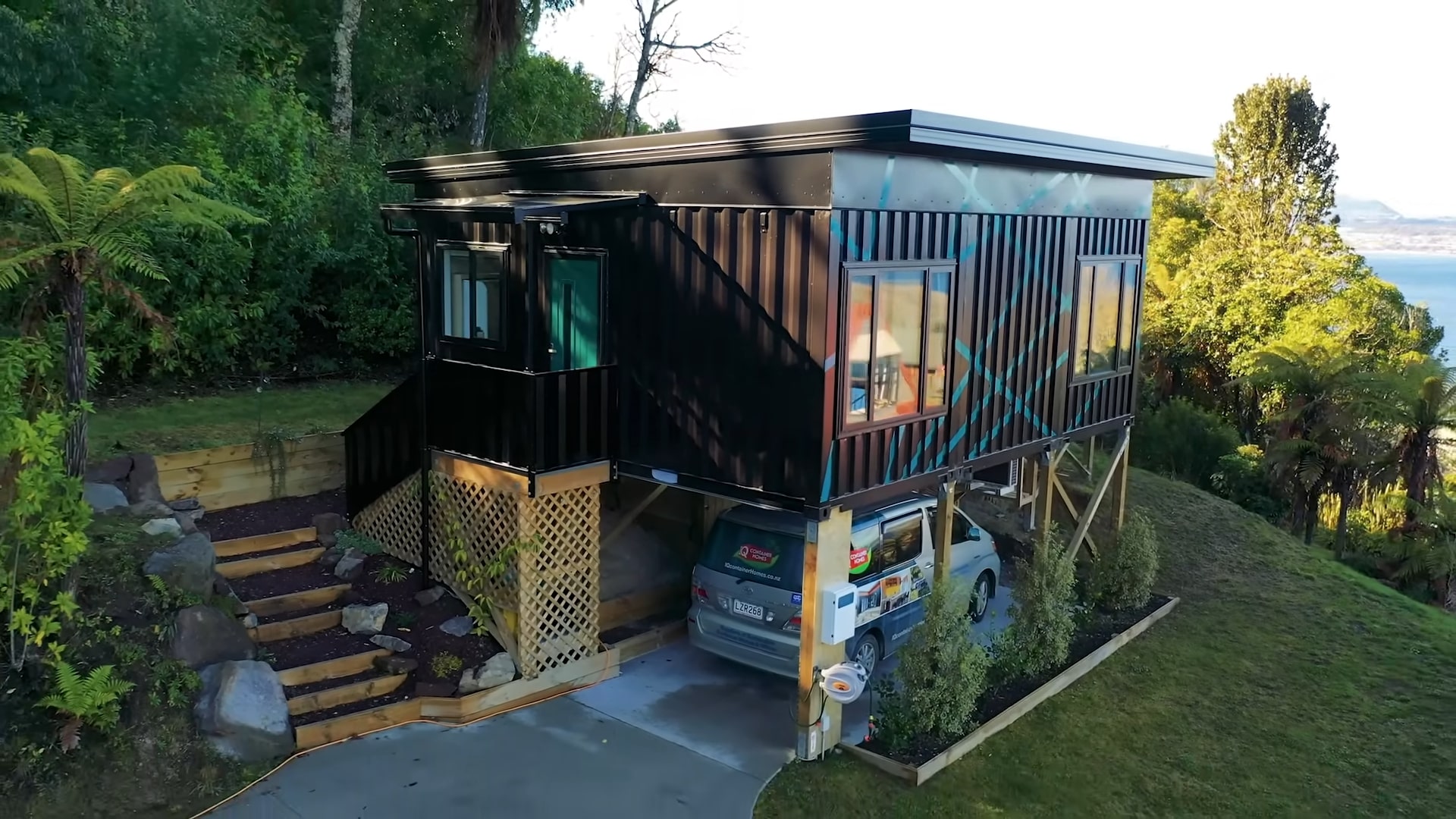 Exterior of an elevated container home with a carport