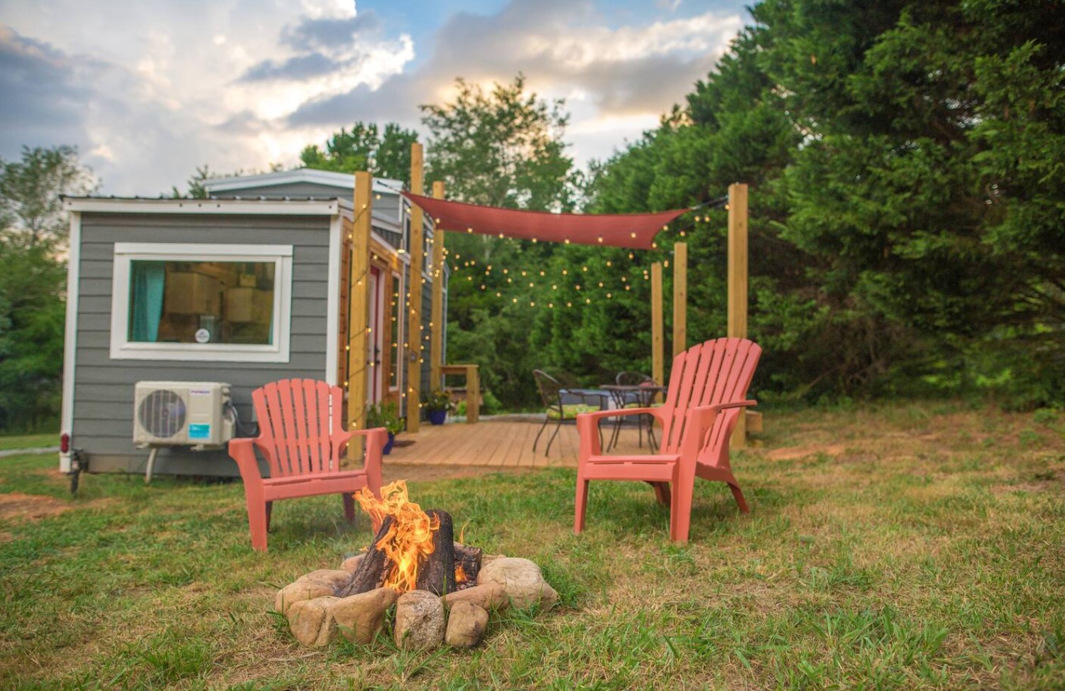 exterior of tiny house with a fireplace and light up patio