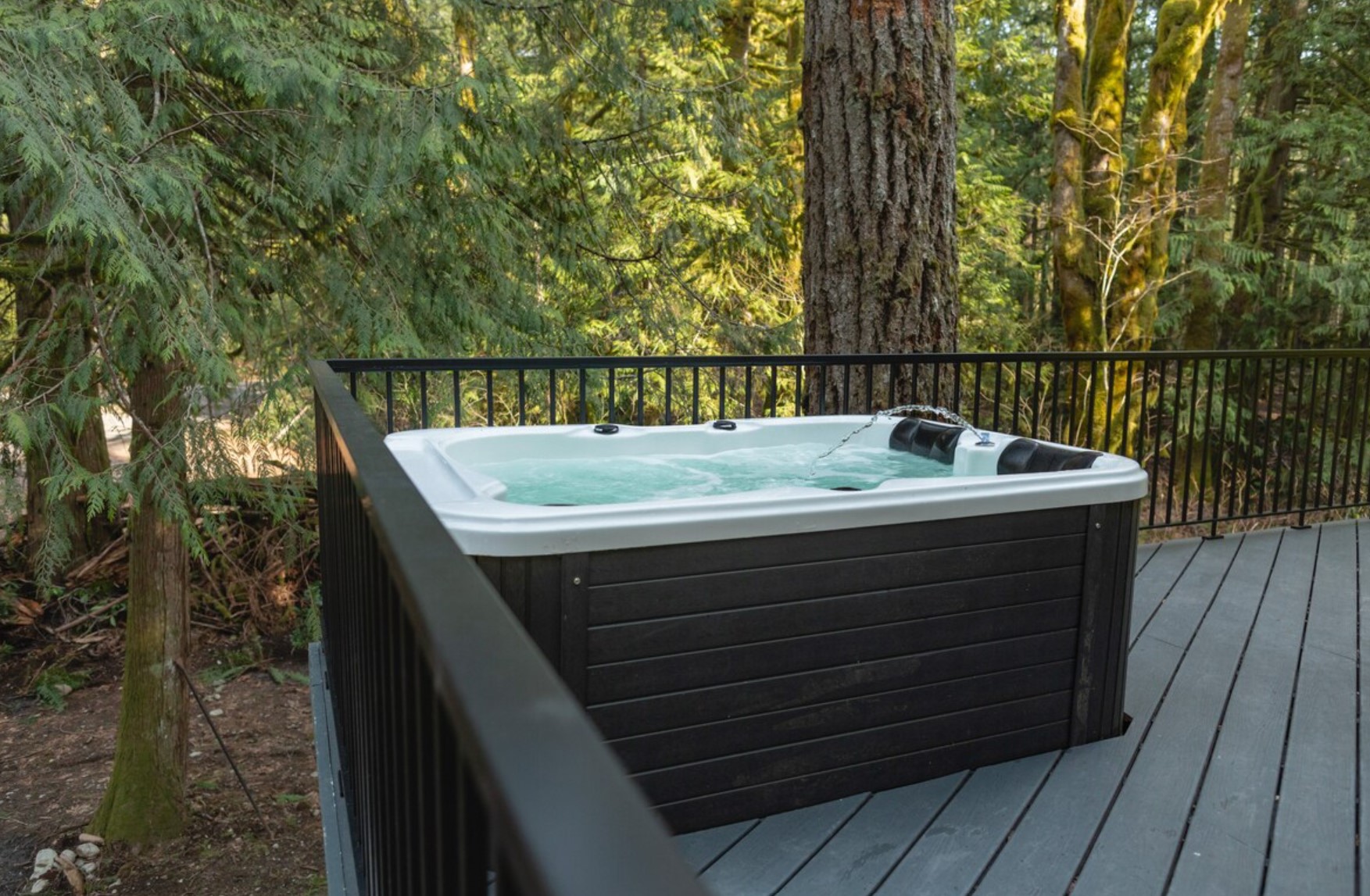 container home with a hot tub on the balcony