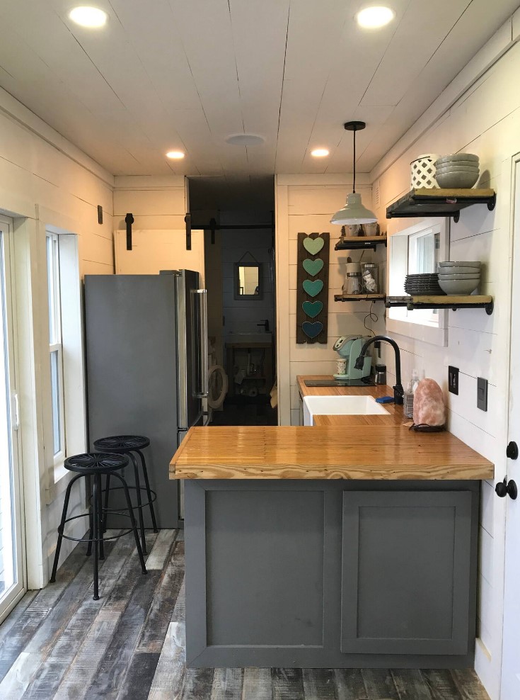 Kitchen in container cabin with full fridge and open shelves