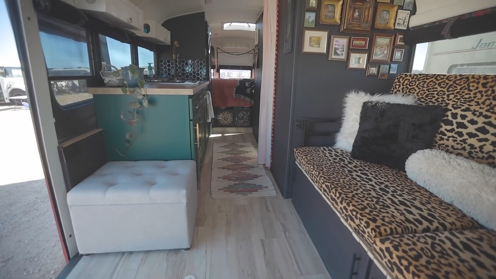 Main living area in a bus home with a couch and a long hall way