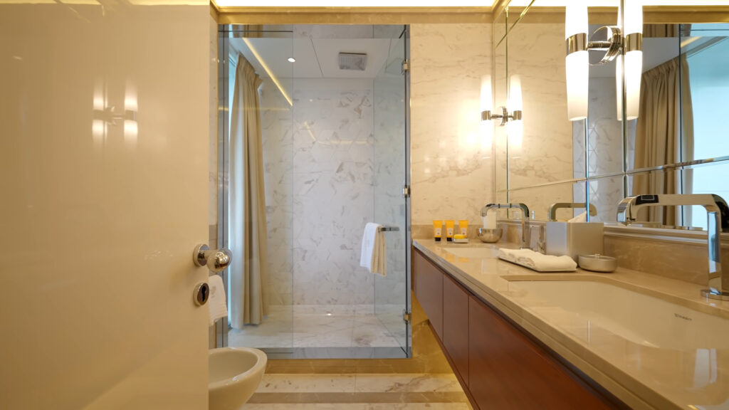 Marble bathroom with a floating vanity and yellow lights