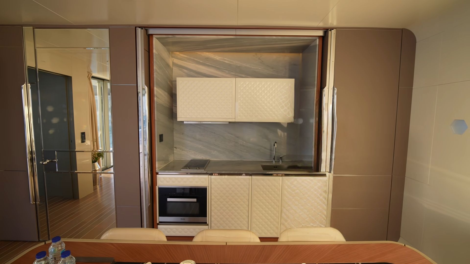 Marble kitchen with white cupboards and a hidden kitchen