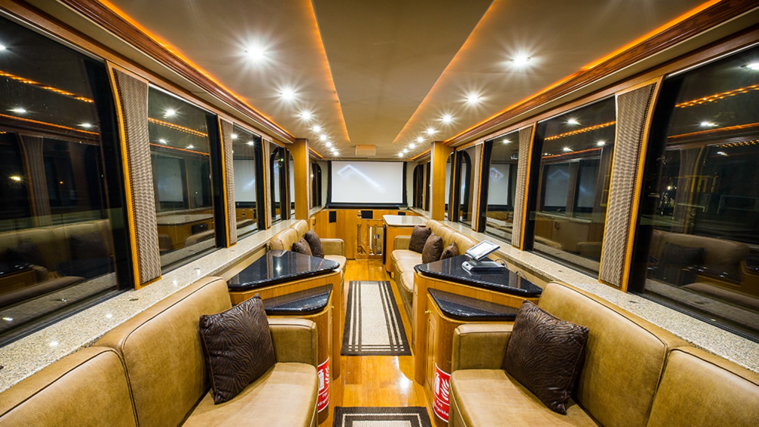 Lounge area in motorhome with a projector screen and leather couches