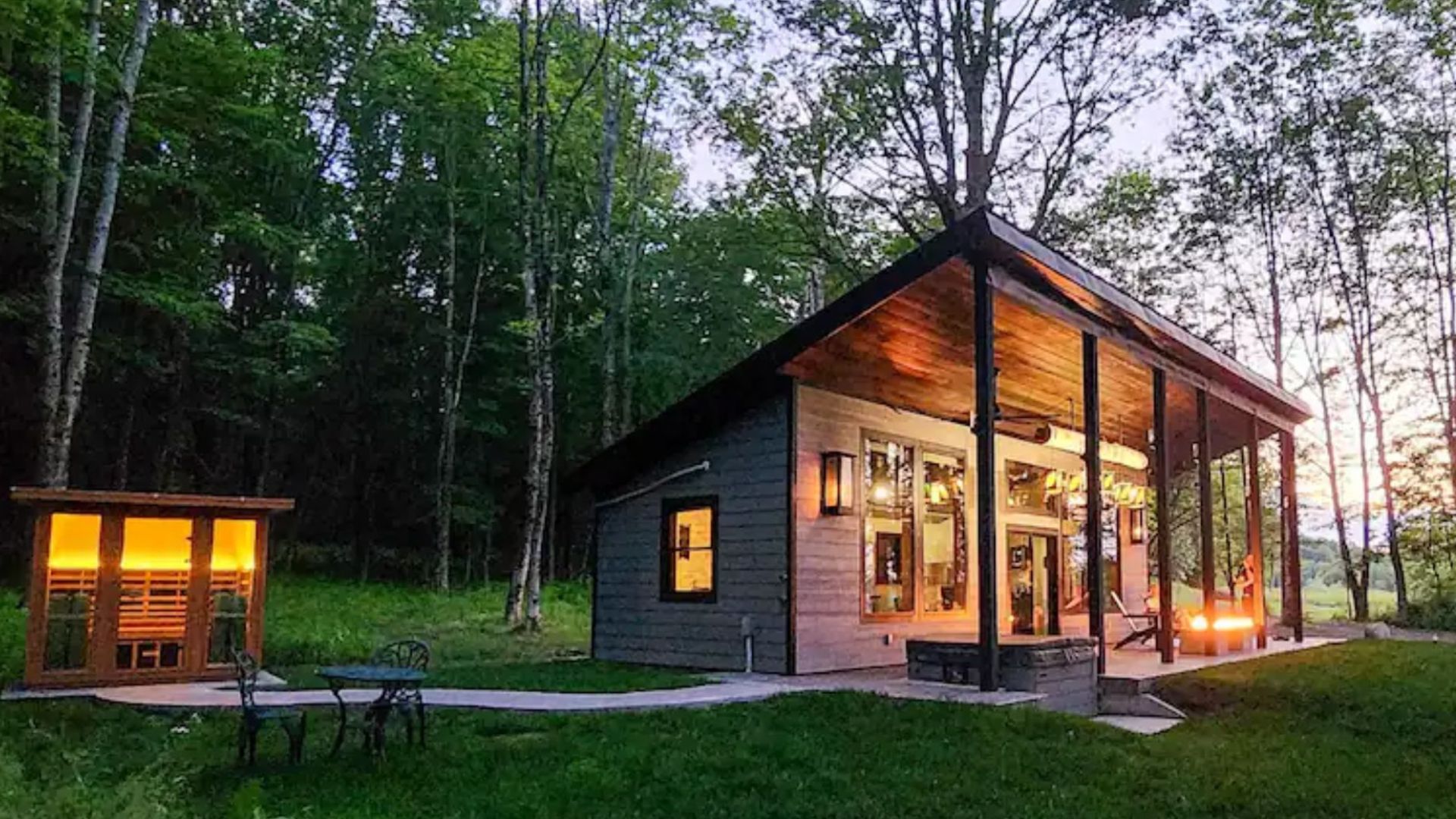 tiny house hickory outpost in the woods with a small sauna next to it