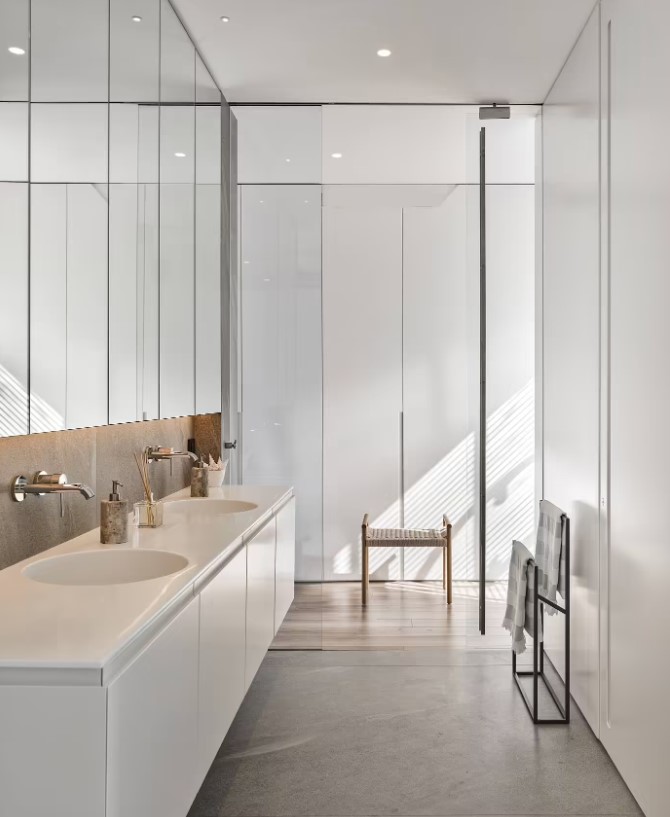 bathroom with a brown cabinet and two sinks and a big mirror above