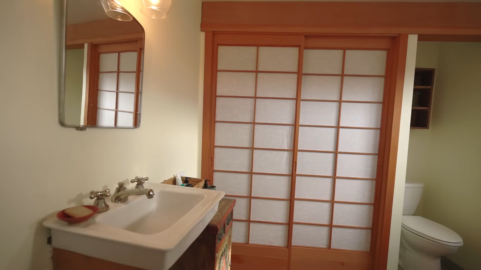 bathroom with a white sink, a mirror and a closet with shoji doors