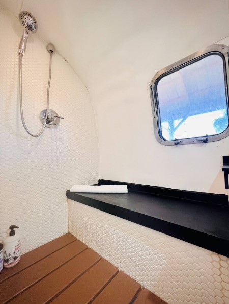 bathroom of a tiny camper house with a seating area and a window