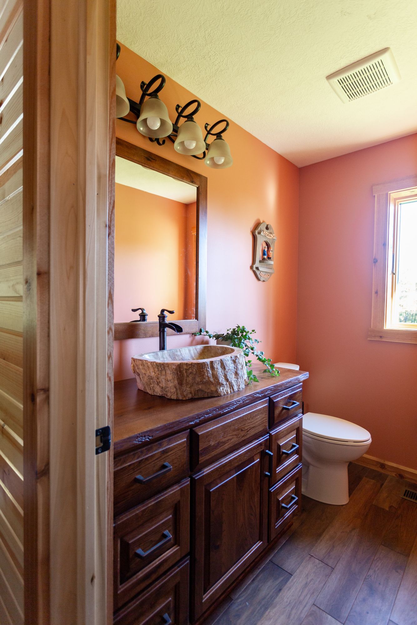 bathroom with a brown cabinet, a wooden sink and white toilet