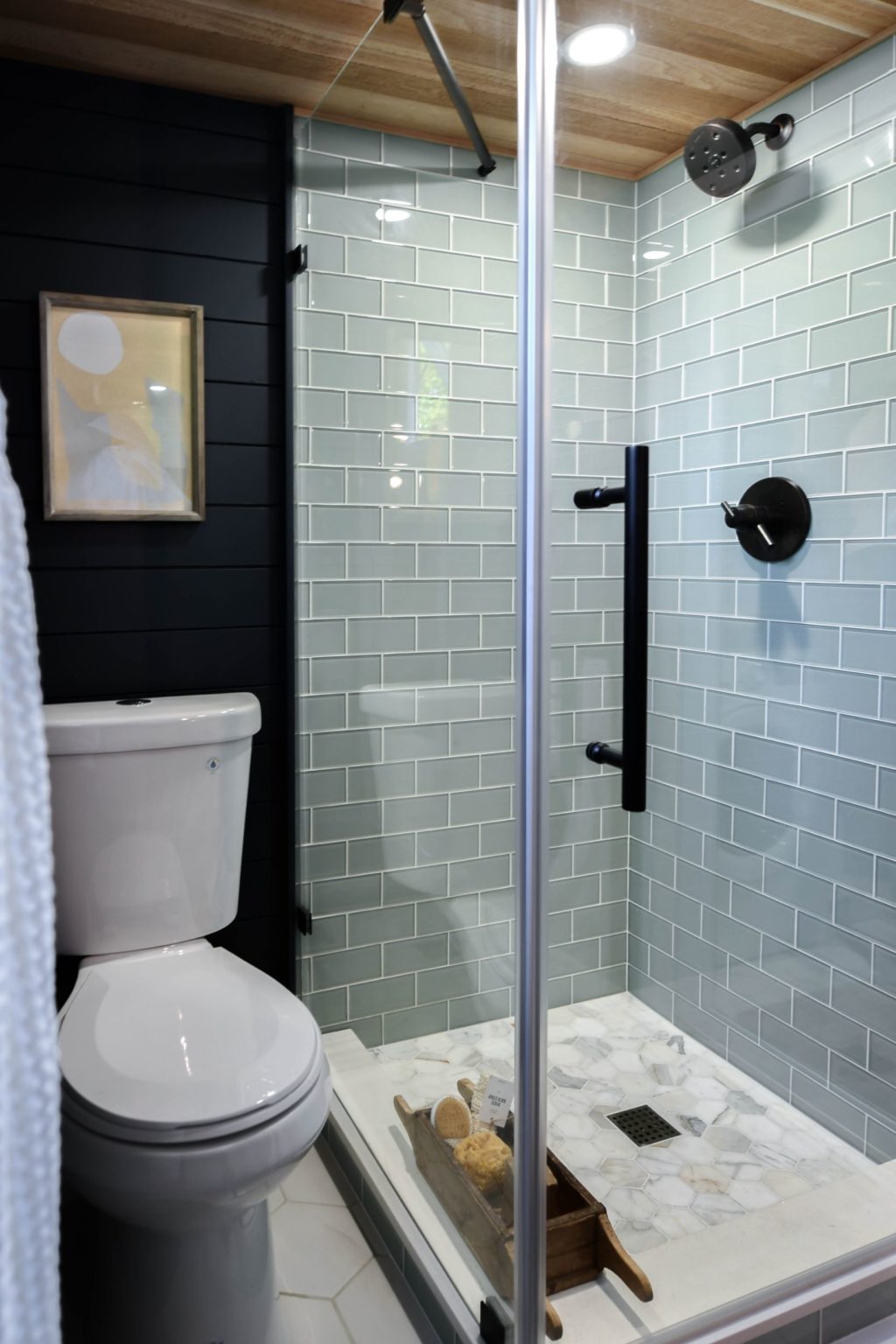 bathroom with light green tiles and a white toilet