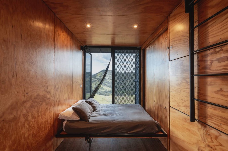 bed inside of the bedroom with brown walls and glass door