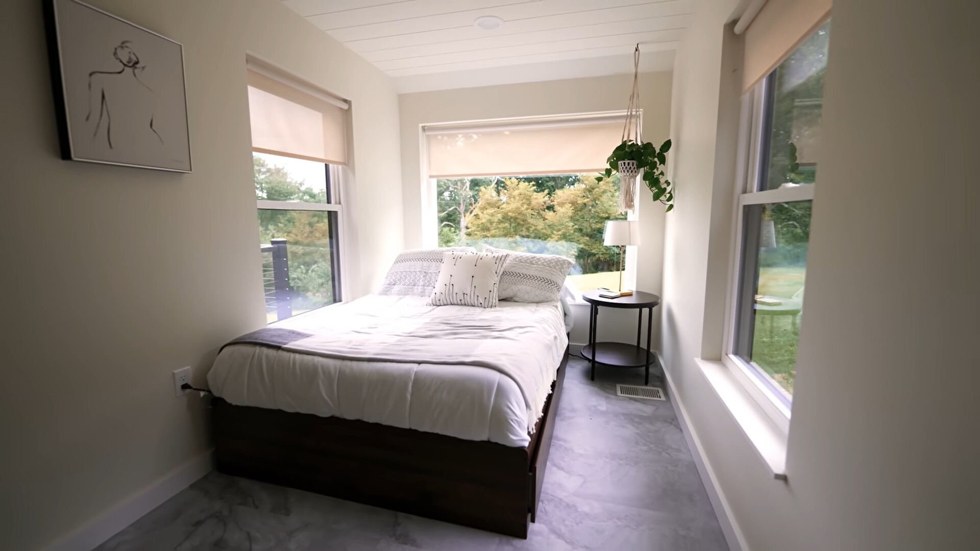 bedroom with windows all around and a black bedside table