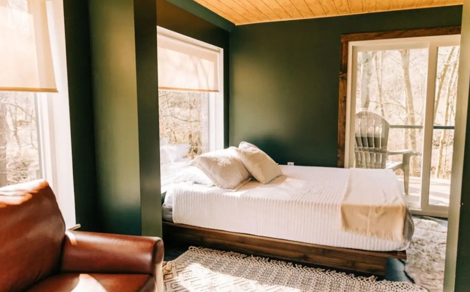 bedroom with a dark green wall and a balcony