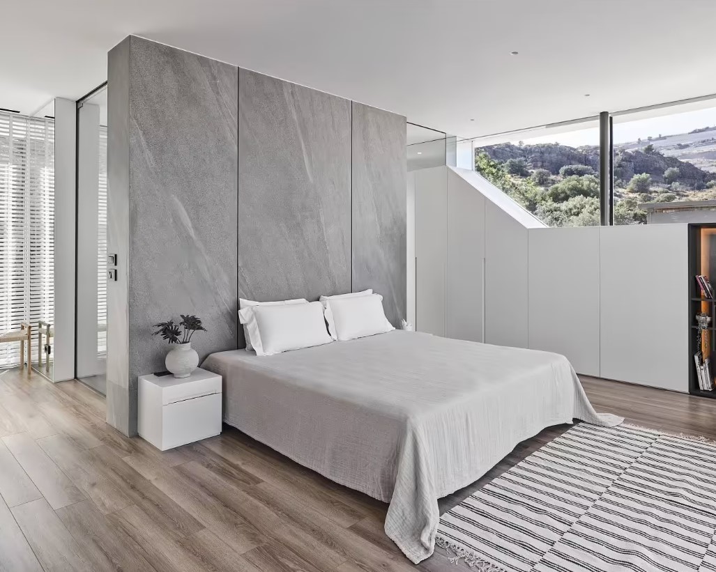 bedroom with a gray wall and unique high positioned window