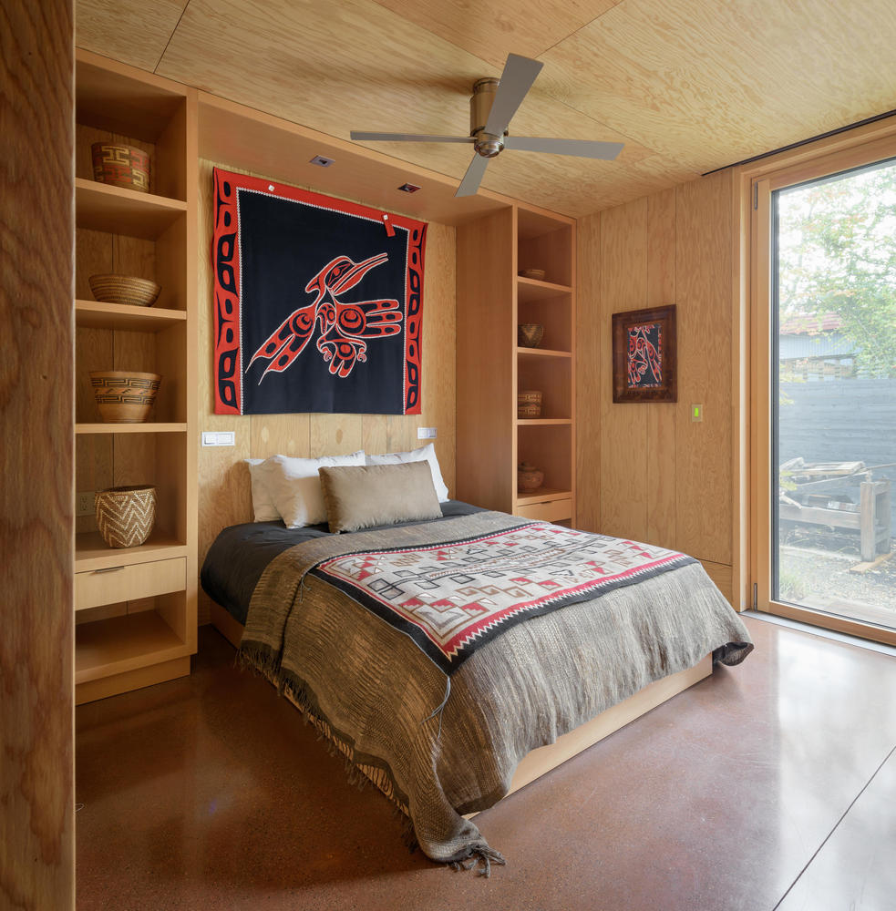 bedroom with shelves around the bed and a floor to ceiling window