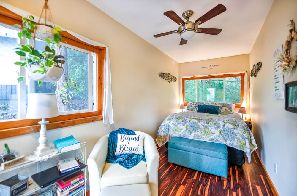 bedroom with two windows, a white sofa and a white shelf