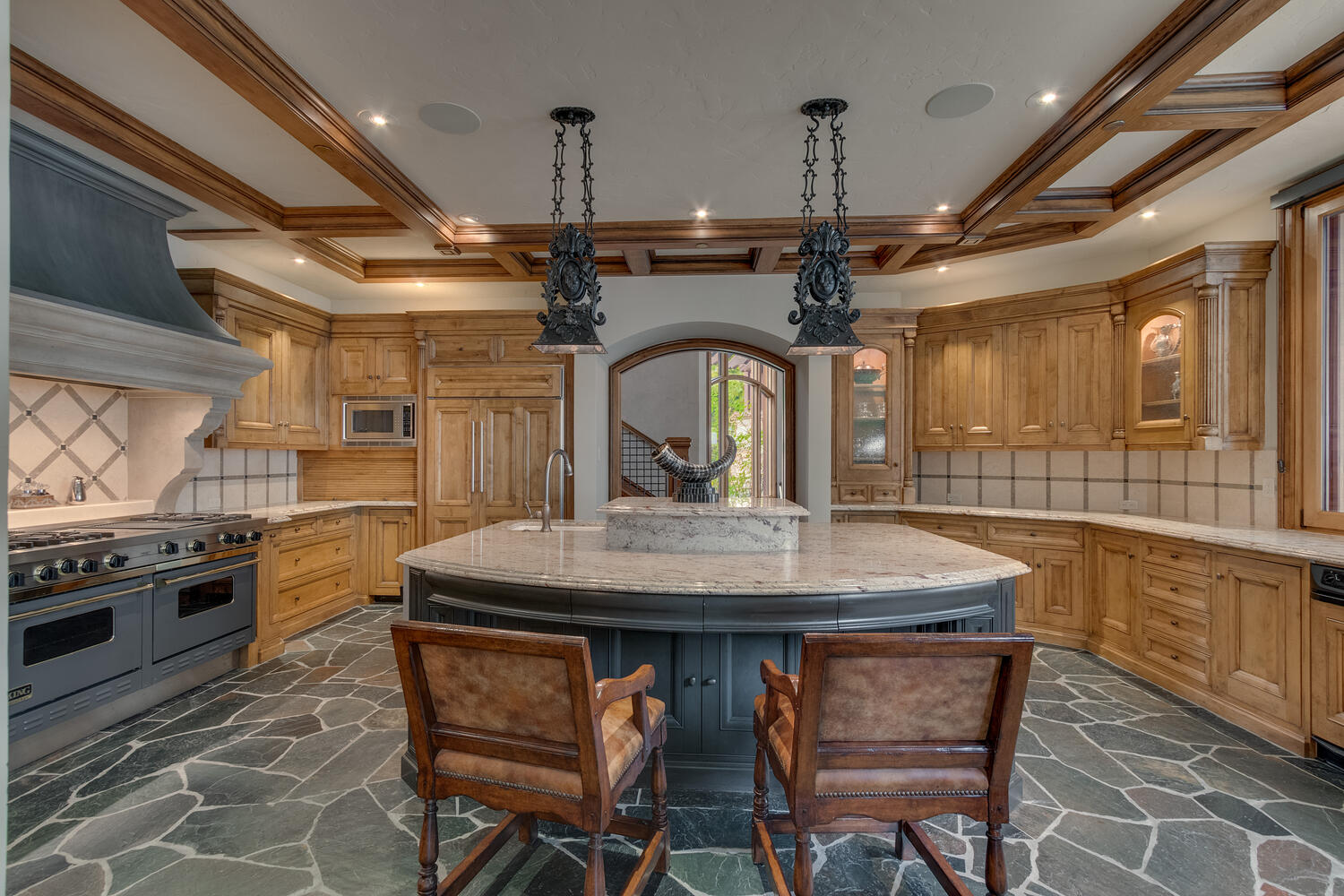 kitchen with marble countertop, island in the middle of the room, brown cabinet