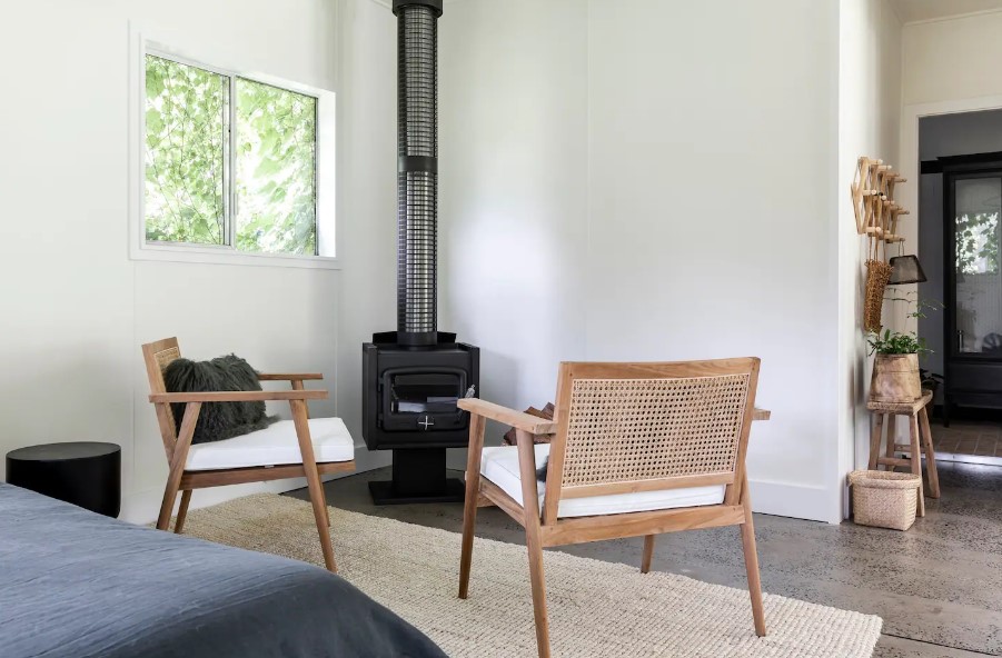 bedroom with a black fireplace and two chairs